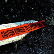Orange burial tape with the text, "caution buried telephone line."