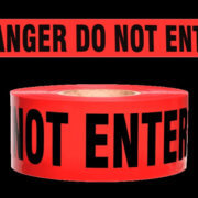 Red barricade tape that partially reads, "DANGER DO NOT ENTER" in a bold black font against a black background.